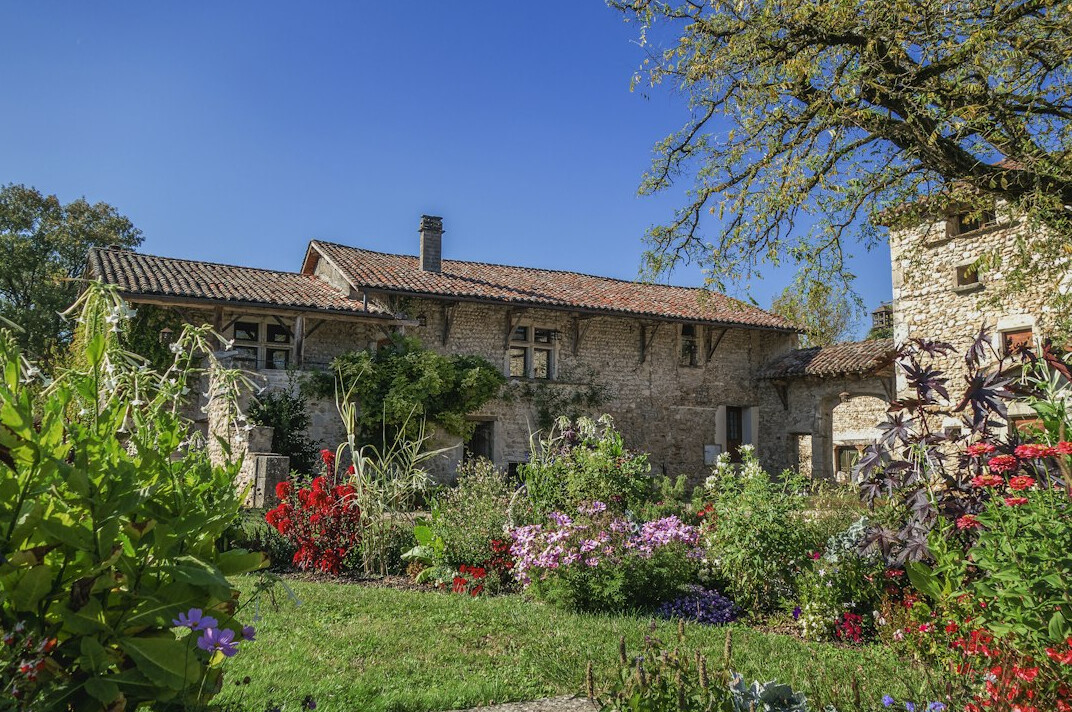 Villa moderne avec jardin et façade en pierre au coucher du soleil